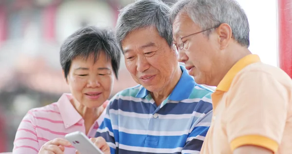 Bejaarde Vrienden Kijken Naar Mobiele Telefoon Samen — Stockfoto