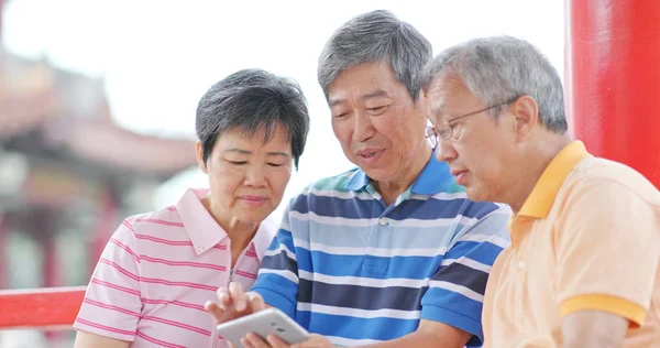 Senior Vrienden Praten Samen Kijken Naar Buiten Park Mobiele Telefoon — Stockfoto