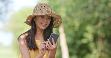 Şapka saman ve çekici fotoğraf açık, cellphone tarafından giyen kadın