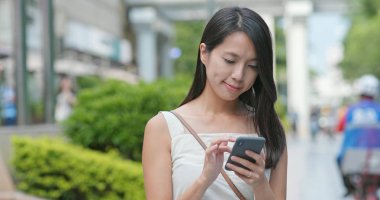 Genç kadın cellphone şehir içinde App kullanma