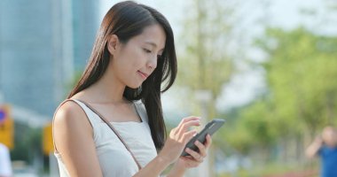 Asyalı kadın cellphone şehir içinde App kullanma