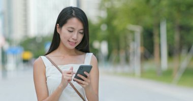 Şehirde smartphone Asyalı kadın bakar