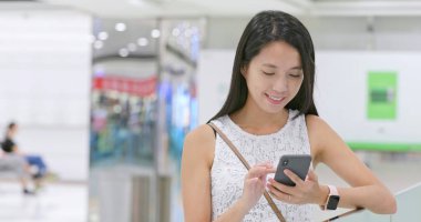 Alışveriş merkezinde Smartphone kullanan kadın