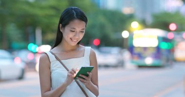 Asyalı kadın geceleri cellphone şehir içinde app kullanma