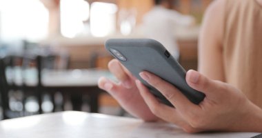 restoranda cep telefonu kullanan kadın