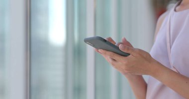 Alışveriş merkezinde cep telefonu kullanan bir kadın.