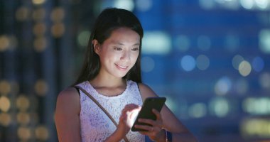 Gece akıllı telefon kullanan bir kadın.