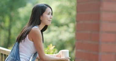 Kadınlar balkonda kahvelerini yudumlarlar.