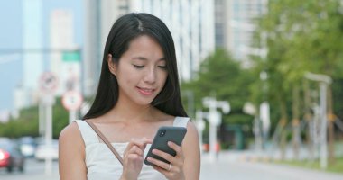 Şehirde smartphone Asyalı kadın bakar