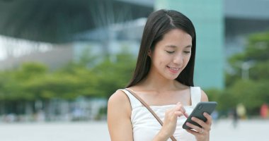 Bir taksi uygulaması ile açık, aradığınız için cep telefonu kullanan kadın