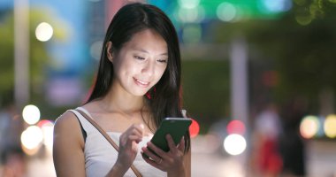 Gece akıllı telefon kullanan bir kadın.