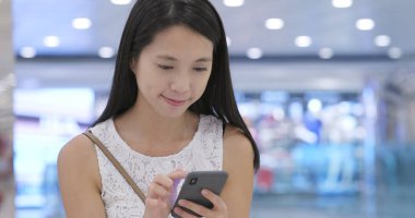 Alışveriş merkezinde Smartphone kullanan kadın