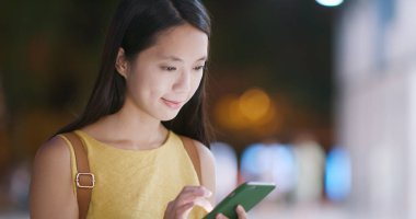 Cep telefonuyla Shenzhen şehir içinde geceleri kadın