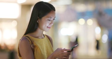 Alışveriş Merkezi dışında cep telefonu kullanan kadın