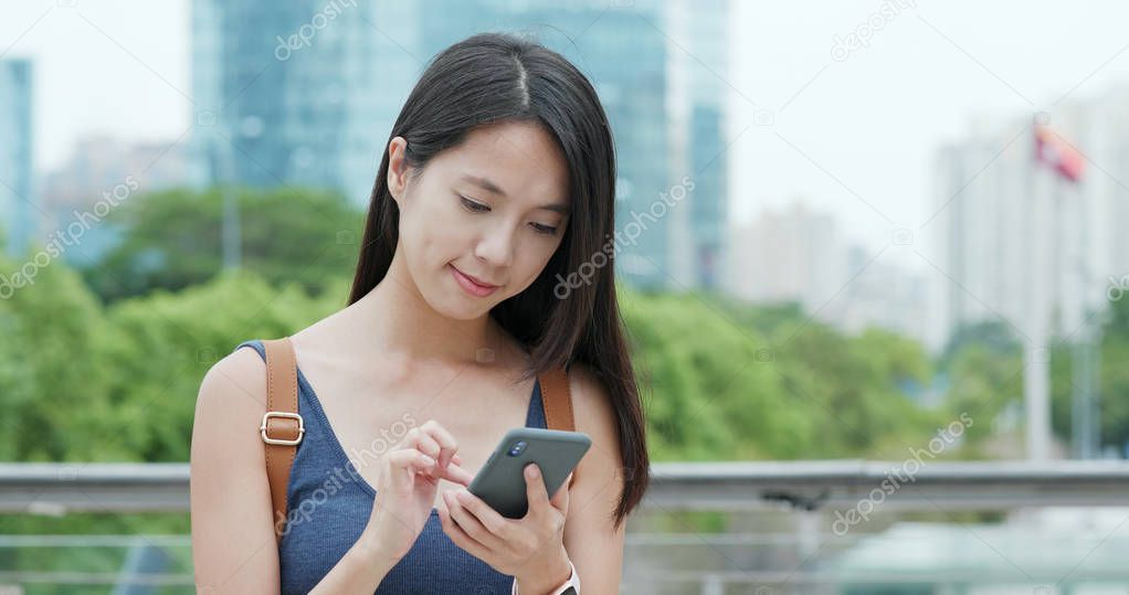 Woman sending sms on cellphone in city of Shenzhen