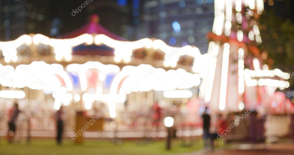 Blur view of carousel in amusement park in the evening