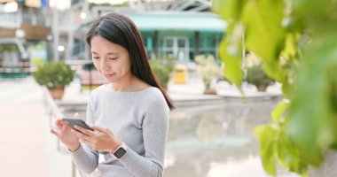 Mobil uygulaması, açık olup olmadığını denetlemek için akıllı telefon kullanan kadın