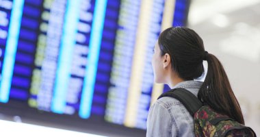 Kadın havaalanında görüntü panosunda bakarak seyahat