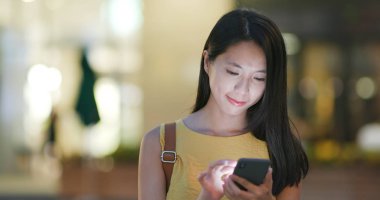 Smartphone şehirde geceleri kullanan kadın seyahat