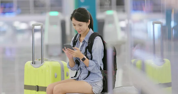 使用手机检查机场航班号码的妇女 — 图库照片