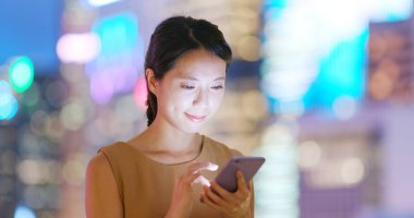 Şehirde akıllı telefon kullanan bir kadın