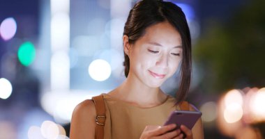 Cep telefonuyla şehirde gece kadın