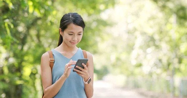 在绿色背景下使用手机的妇女 — 图库照片