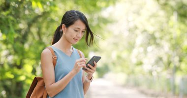 Kadın iş üstünde hareket eden telefon yeşil arka plan üzerinde 