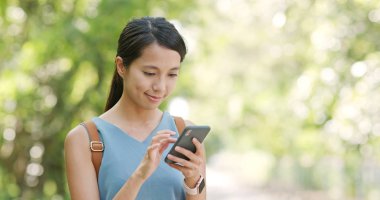 Kadın iş üstünde hareket eden telefon yeşil arka plan üzerinde 