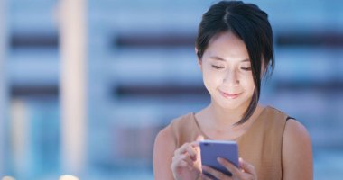 Cep telefonu şehirde geceleri kullanan kadın