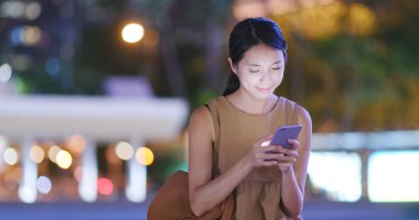 Cep telefonuyla şehirde gece kadın