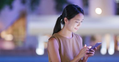 Cep telefonuyla bulanıklık şehir gece ile kadını