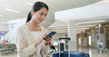 Havaalanında cep telefonu kullanan kadın