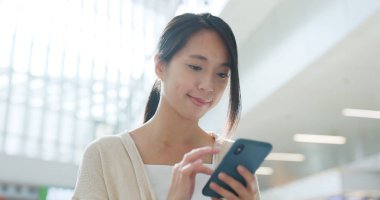 Havaalanında cep telefonu kullanan kadın