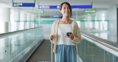 Havaalanında cep telefonu kullanan kadın