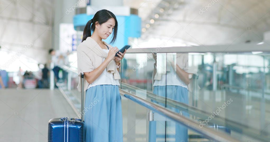 Woman checking flight number on cellphone in the airport