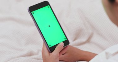 Smartphone ile yatakta Kroma anahtar kullanan kadın