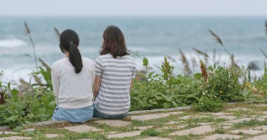 Birbirinizle konuşmak ve deniz kenarında oturan arkadaşlar