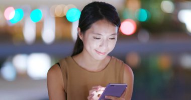 Cep telefonuyla şehirde gece kadın