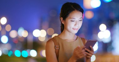 Cep telefonuyla bulanıklık şehir gece ile kadını