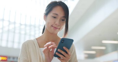 Havaalanı içinde cep telefonu kullanan kadın