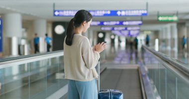 Havaalanında cep telefonu kullanan kadın