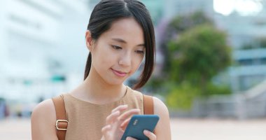 Sokakta cep telefonu kullanan kadın.