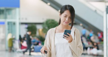 Havaalanında cep telefonu kullanan kadın