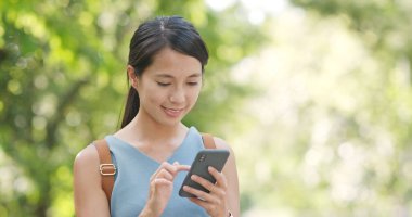 Yeşil arka plan üzerinde cep telefonu kullanan kadın