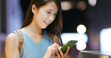 cep telefonuyla şehirde gece kadın