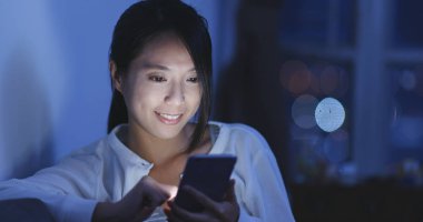 Cep telefonu evde akşamları kullanan kadın