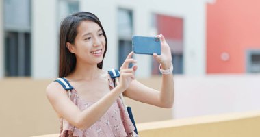Woman taking photo on cellphone in Shum Yip upperhills clipart