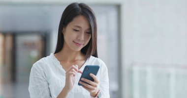 Alışveriş merkezinde cep telefonu kullanan bir kadın.