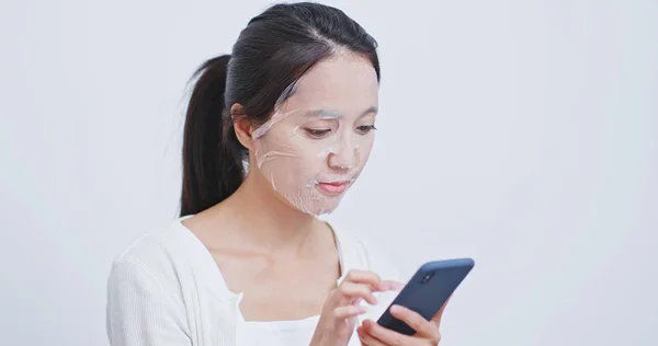 Vrouw Toepassen Masker Het Gebruik Van Mobiele Telefoon Thuis — Stockfoto